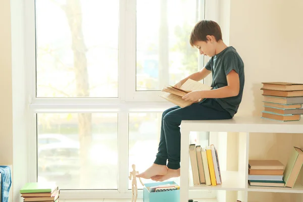 Söt Skolpojke Bredvid Fönster Och Läsa Bok — Stockfoto