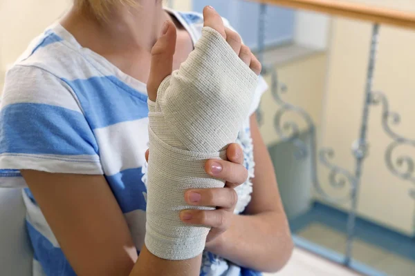 Menina com bandagem na mão — Fotografia de Stock