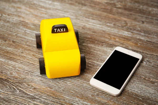 Gele speelgoed taxi met telefoon — Stockfoto