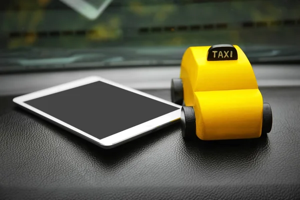 Juguete amarillo taxi con tablet — Foto de Stock