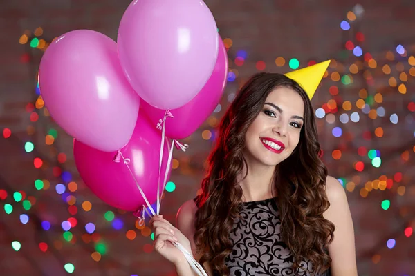 Beautiful young woman with colorful balloons — Stock Photo, Image