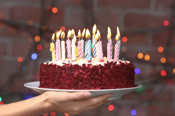 Hand holding plate with birthday cake — Stock Photo, Image