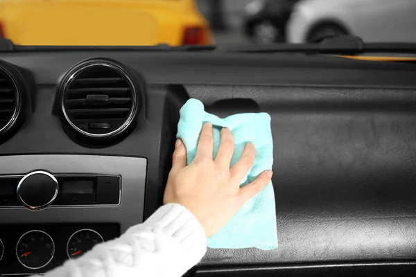 Mujer limpieza de un tablero de instrumentos de coche — Foto de Stock