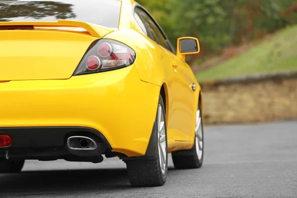 New yellow car on the road — Stock Photo, Image