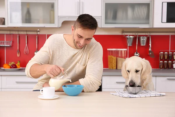 人和狗享用早餐在厨房 — 图库照片