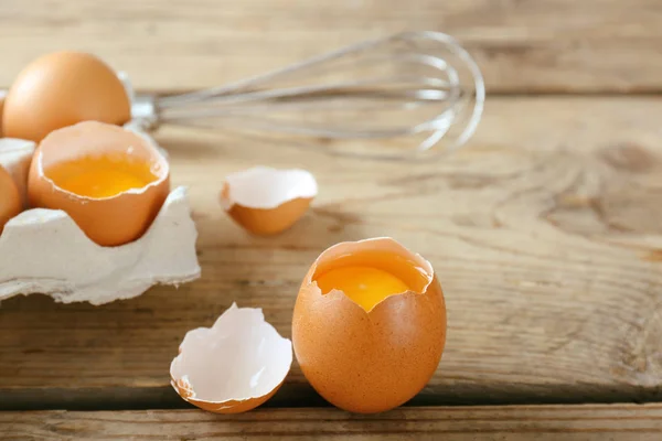 Rohe Eier im Paket mit Schneebesen — Stockfoto