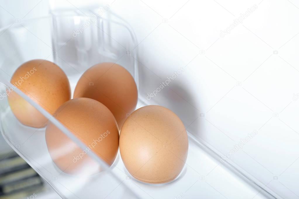 Raw eggs on fridge shelf