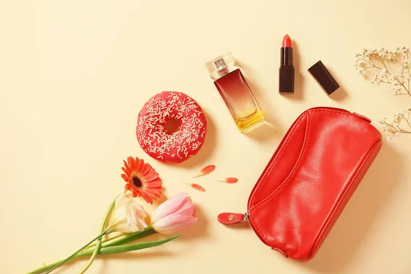 Donut saboroso com flores e cosméticos — Fotografia de Stock