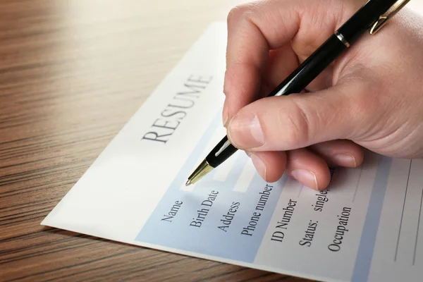 Weibliche Hand Füllt Lebenslauf Auf Holztisch Aus Nahaufnahme — Stockfoto