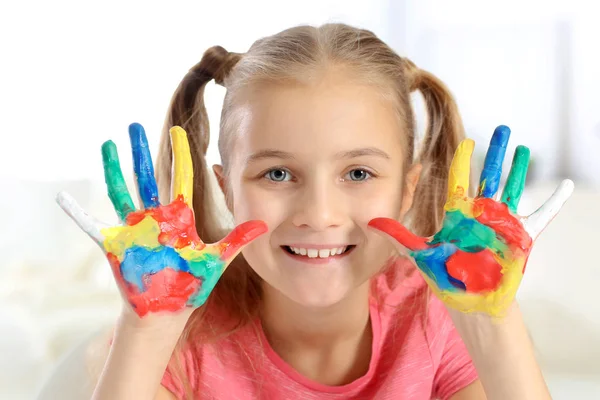 Söt liten flicka med händer i paint — Stockfoto