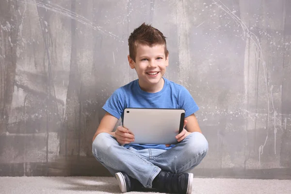 Netter Kleiner Junge Mit Tablet Auf Grauem Strukturiertem Hintergrund — Stockfoto