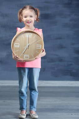 Büyük saat ile sevimli küçük kız