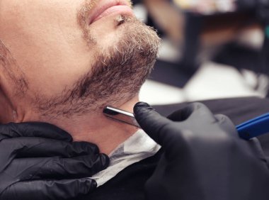 Berber dükkanında tıraş olan kuaför.