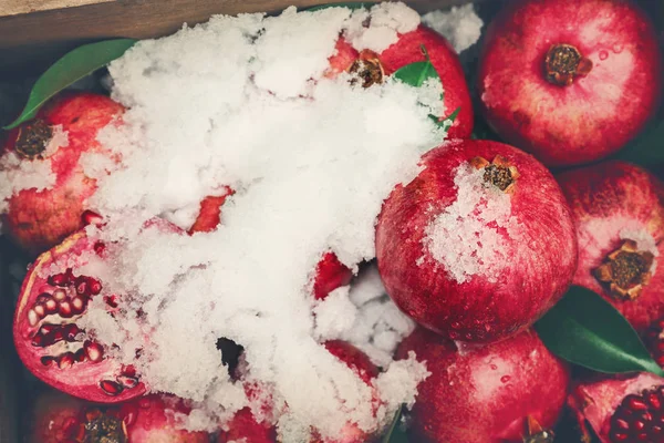 Celá granátová jablka se sněhem — Stock fotografie