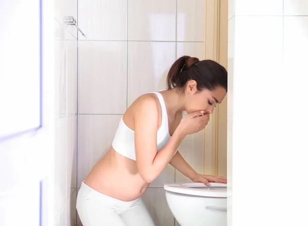 Młoda kobieta wymioty w pobliżu bowl toaleta w domu — Zdjęcie stockowe