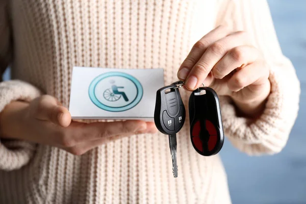 Mujer sosteniendo la llave del coche y tarjeta — Foto de Stock