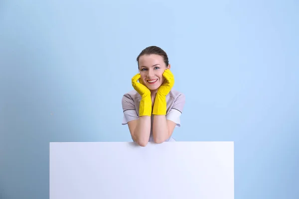 Mooie kamermeisje in uniform op kleur achtergrond — Stockfoto