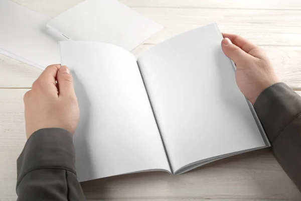 Mãos femininas segurando brochura em branco — Fotografia de Stock