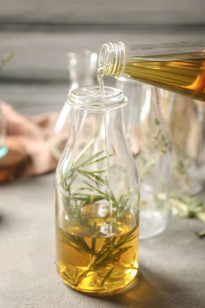Verter aceite en botella con romero — Foto de Stock