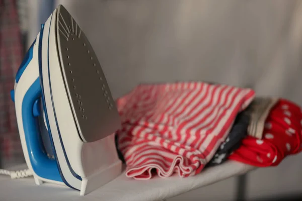 Modern iron and clean clothes — Stock Photo, Image