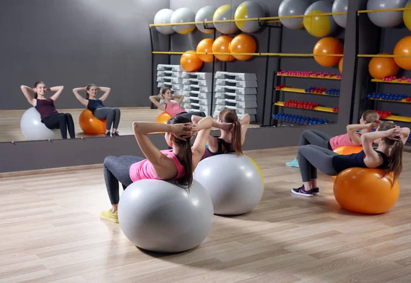 Jovens mulheres esportivas treinando com bolas de fitness no ginásio — Fotografia de Stock