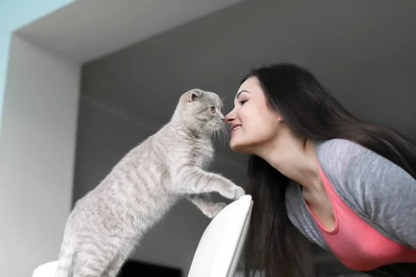 Jovem mulher bonita brincando com gato bonito em casa — Fotografia de Stock