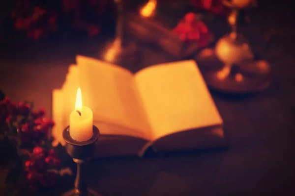 Hořící svíčku a rozmazané Bible — Stock fotografie