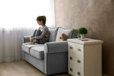 Küçük kız ile oyuncak ayı odasında kanepe