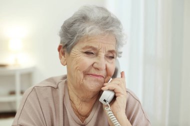 Yaşlı kadın telefonla konuşuyor