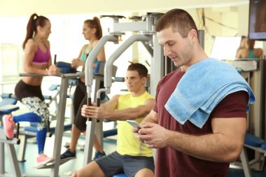 Spor salonunda cep telefonu ile yakışıklı delikanlı