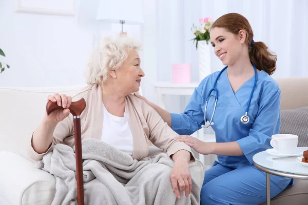 Krankenschwester spricht mit älterer Frau im hellen Raum — Stockfoto