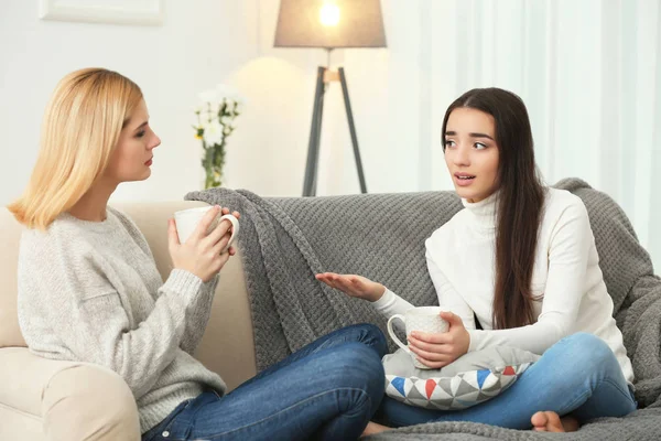 Amici che bevono caffè seduti sul divano di casa — Foto Stock