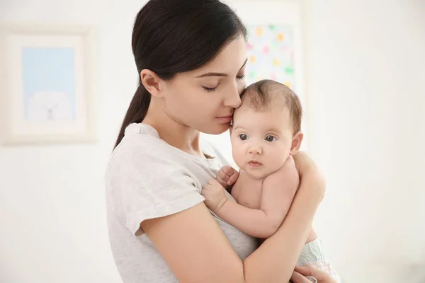 Mãe feliz com bebê pequeno bonito em casa — Fotografia de Stock