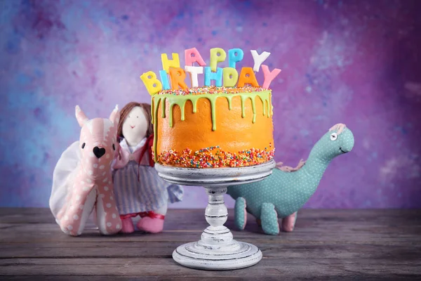 Tasty birthday cake with toys — Stock Photo, Image