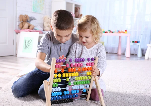 Broer en zus spelen met de abacus — Stockfoto