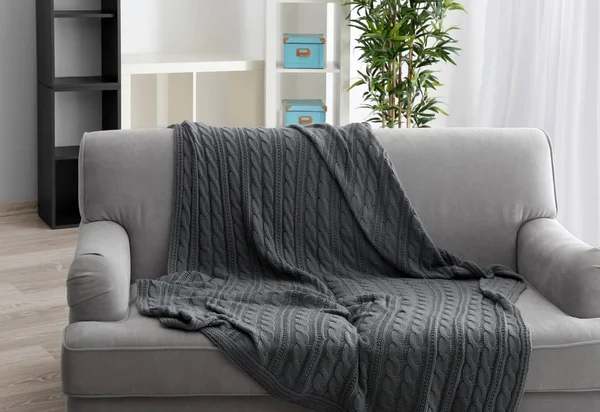Диван с серым одеялом — стоковое фото