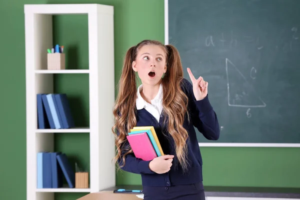 Adolescente em uniforme escolar em pé na sala de aula — Fotografia de Stock