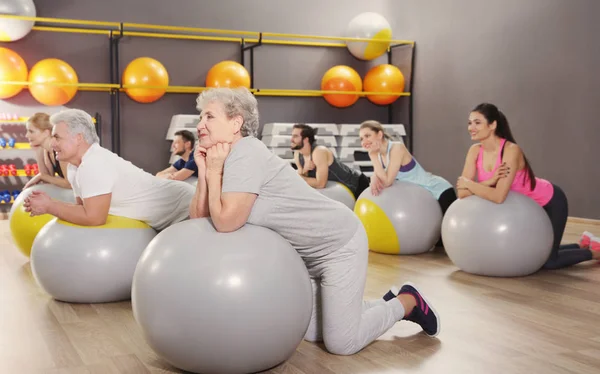 Personas de diferentes edades entrenando con pelotas en forma en el gimnasio —  Fotos de Stock