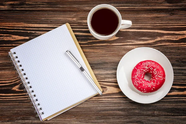 Velsmagende donut med kop kaffe og notesbog - Stock-foto
