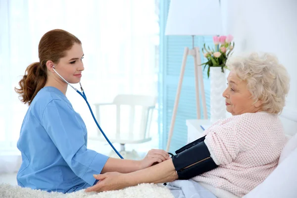 Medição da pressão arterial da mulher com tonômetro — Fotografia de Stock