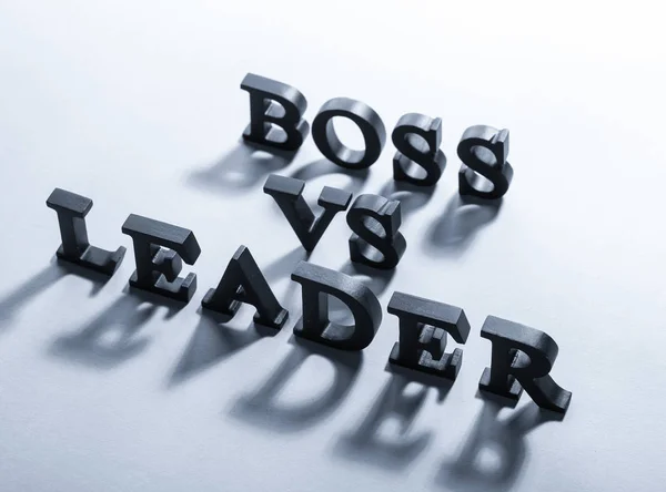 Black letters forming text BOSS VS LEADER on grey background — Stock Photo, Image