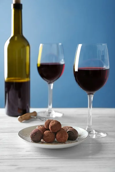 Pralinen und Gläser mit Wein — Stockfoto