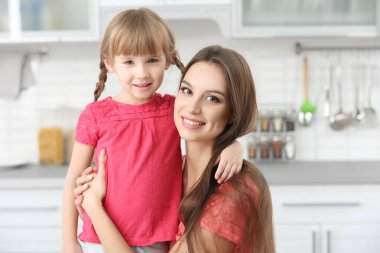 Genç mutfak at kucaklayan küçük kız anne