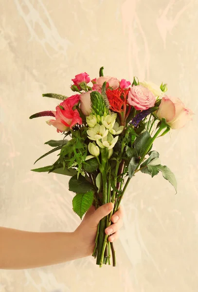Γυναίκα χέρι κρατώντας μπουκέτο λουλούδια — Φωτογραφία Αρχείου