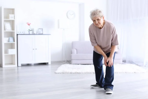 Starsza kobieta cierpi na ból w kolanie — Zdjęcie stockowe