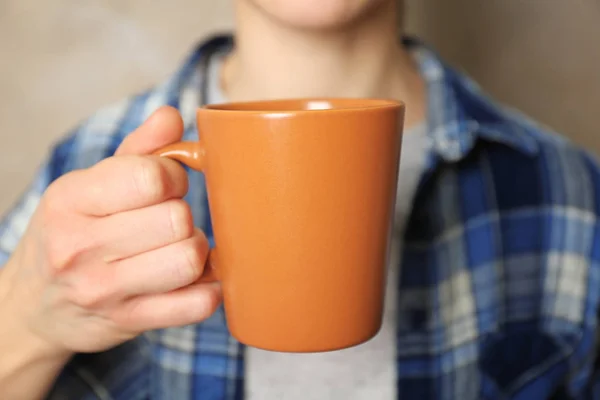 Blank orange cup in hand — Stock Photo, Image