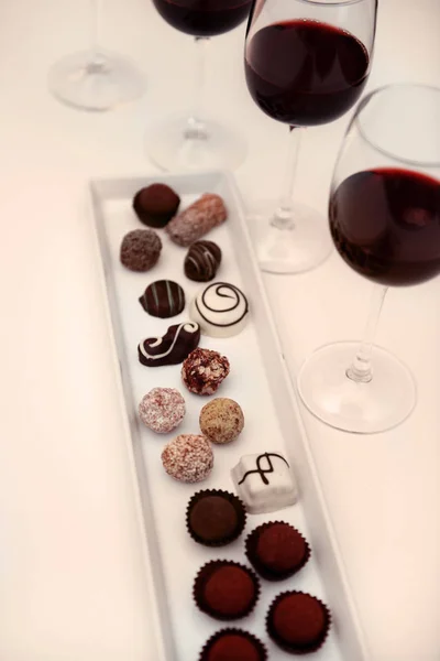 Delicious chocolates and glasses of wine — Stock Photo, Image