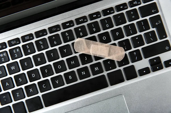 Klawiatury laptopa z plastrem — Zdjęcie stockowe