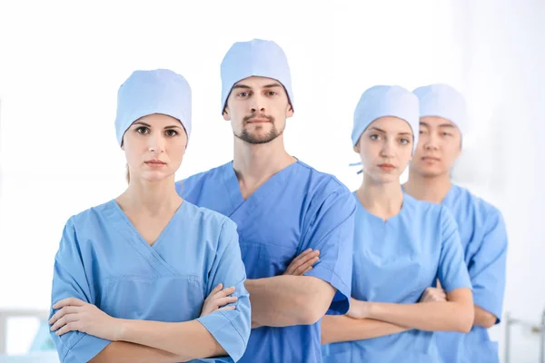 Beautiful young doctor with colleagues in clinic — Stock Photo, Image