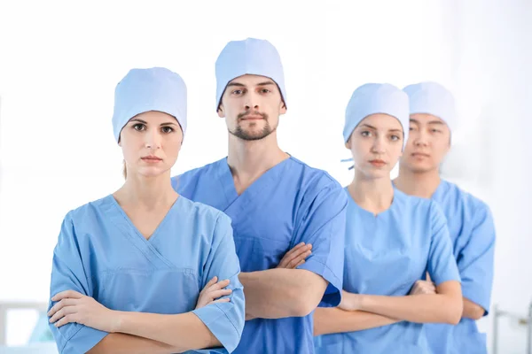 Jovem médico bonito com colegas na clínica — Fotografia de Stock